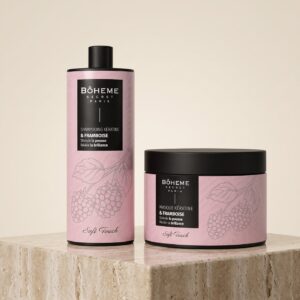 Duo shampooing et masque kératine framboise Bôheme Secret Paris posés sur un socle de travertin devant un fond crème