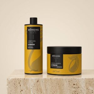 Duo shampooing et masque kératine mangue Bôheme Secret Paris posés sur un socle de travertin devant un fond crème